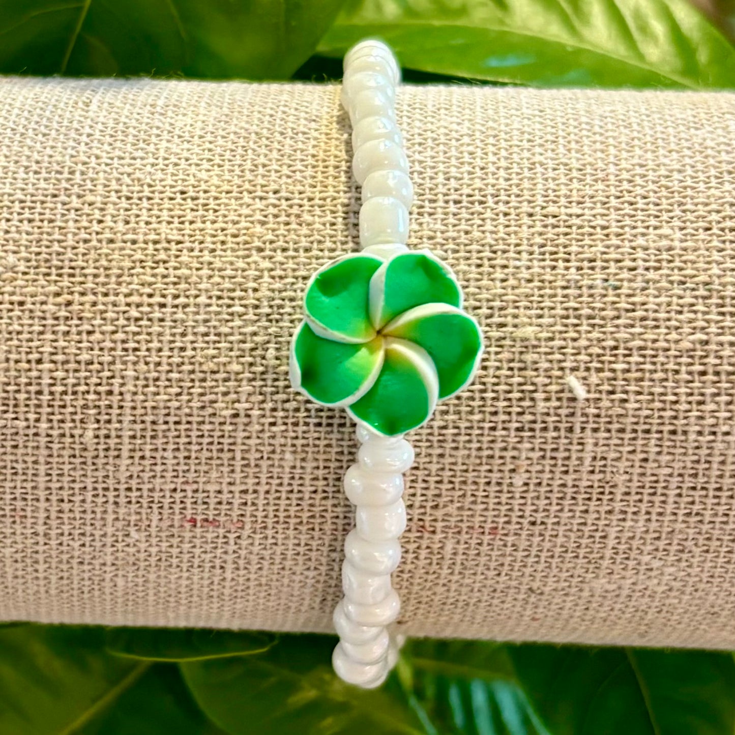 Armband mit weißen Perlen und Hawaiiblume Armband mit weißen Perlen und Hawaiiblume