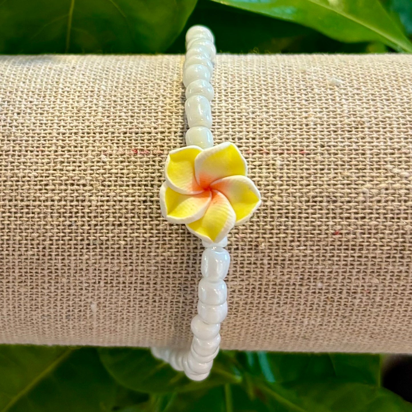 Armband mit weißen Perlen und Hawaiiblume Armband mit weißen Perlen und Hawaiiblume