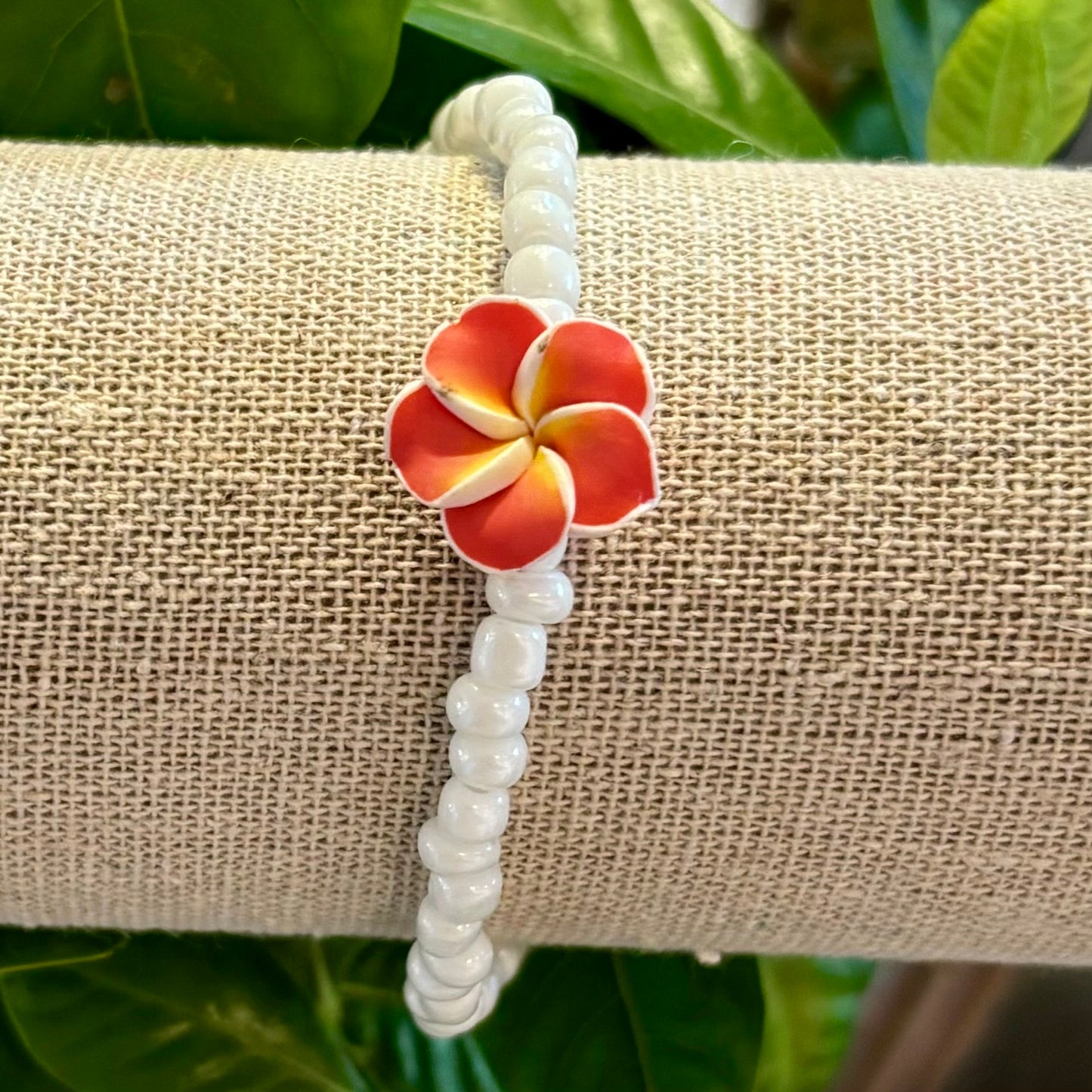 Armband med vita pärlor och hawaiisk blomma Armband med vita pärlor och hawaiisk blomma